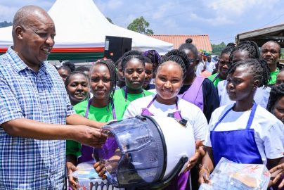 Nyamira Governor Amos Nyaribo (centre) presents a working toolkit to one of the best well performed VTC graduate at Mwongori VTC.